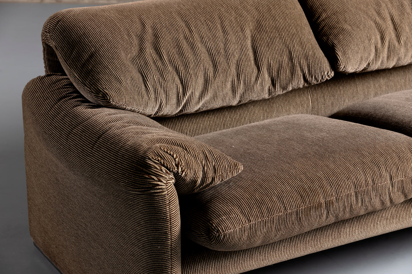 Arm rest of a 2 seater brown sofa