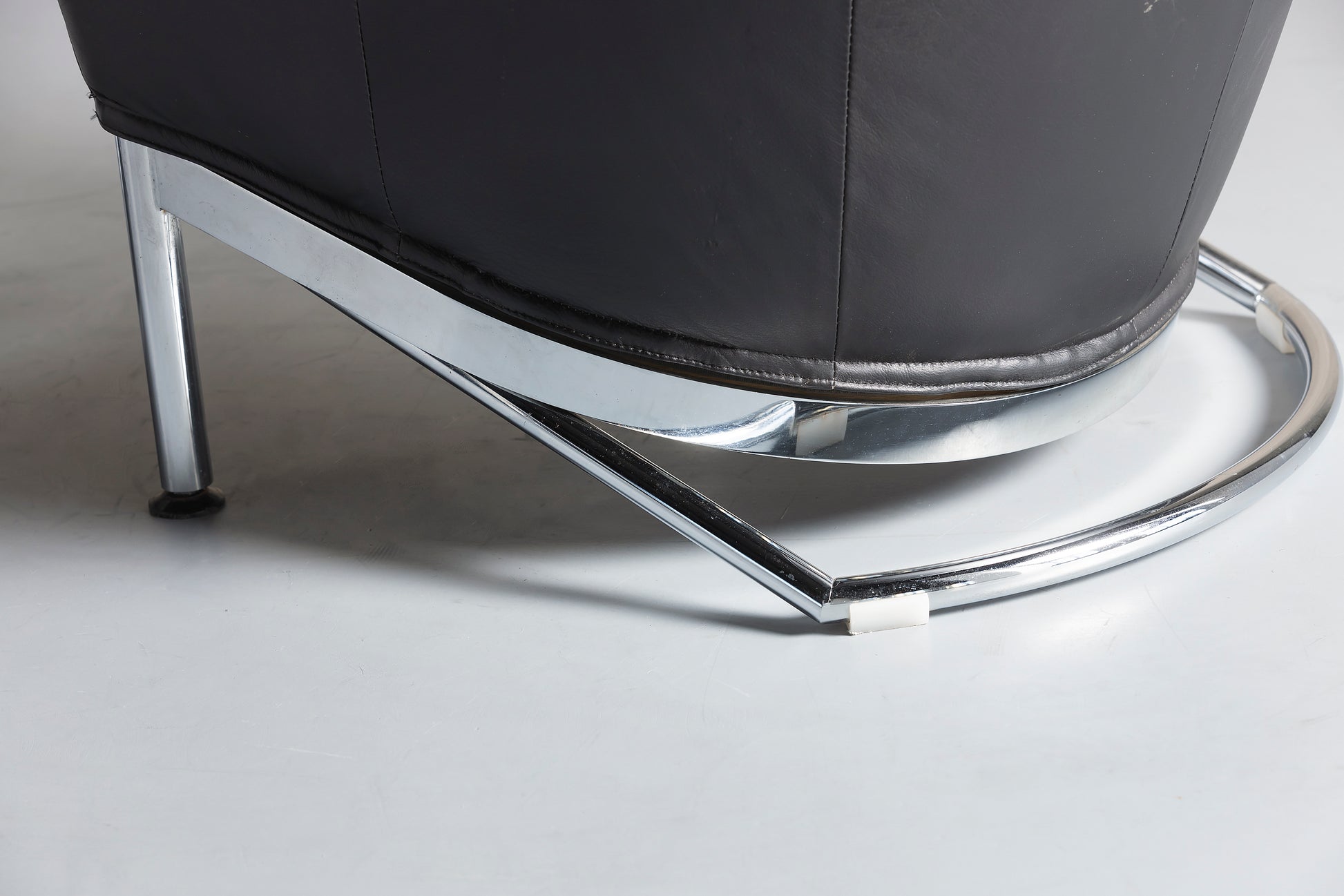 Chrome legs of a black leather chair