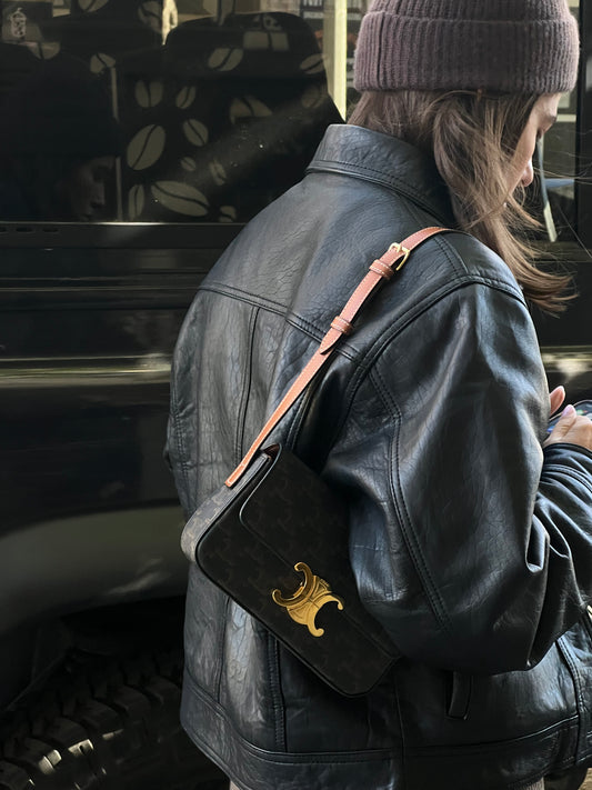 woman wearing a black leather jacket and a purse