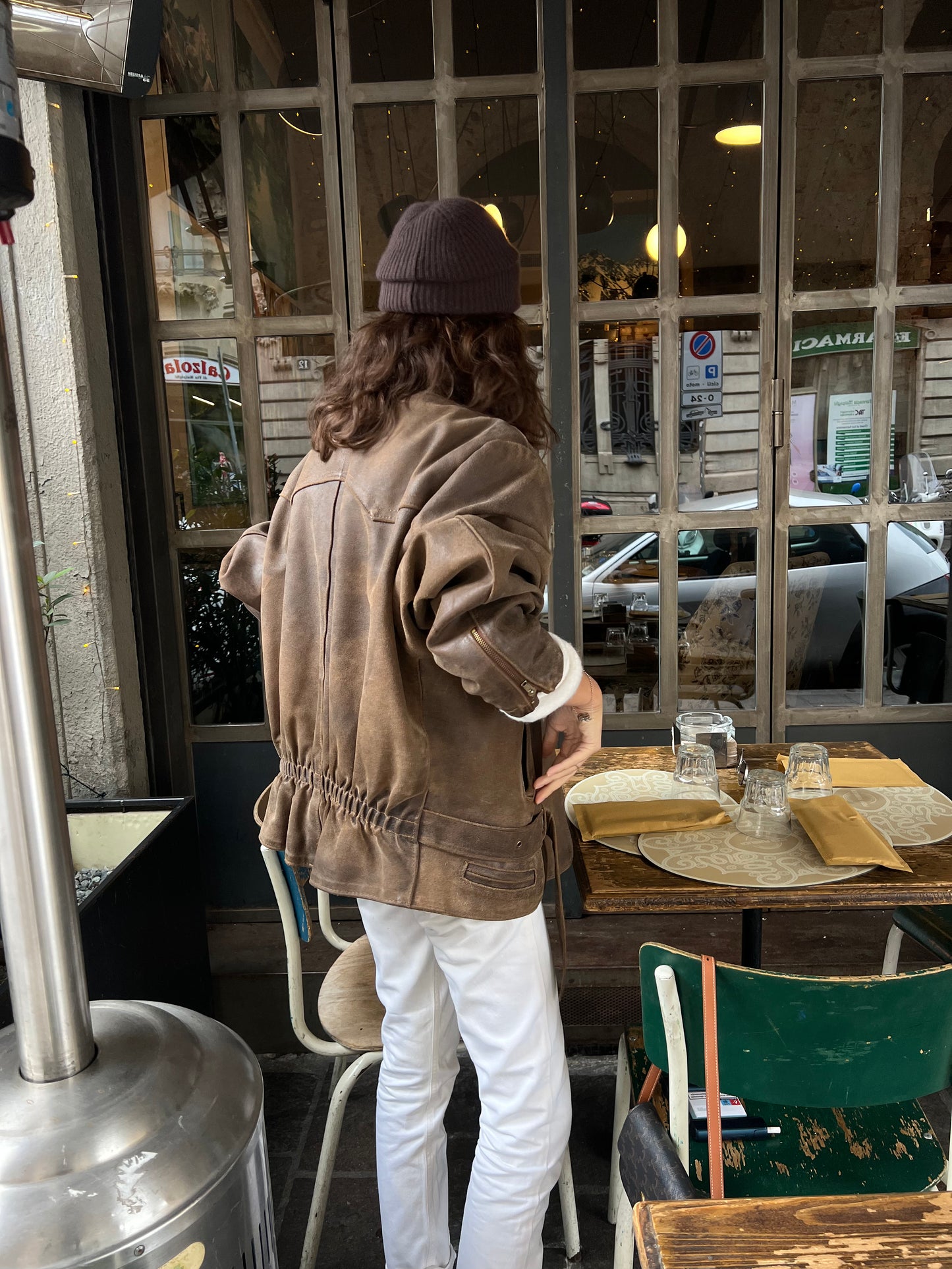woman wearing a brown woman’s bike leather jacket looking away